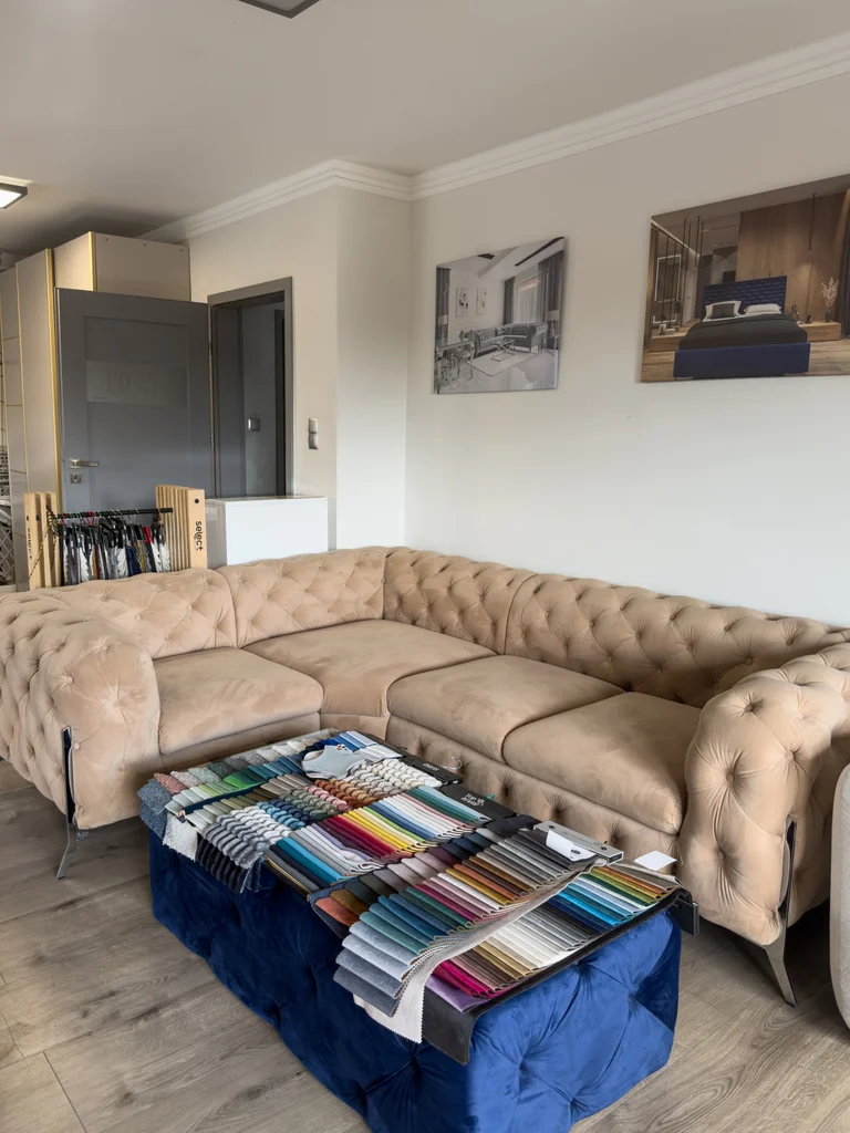 Beżowy pikowany narożnik i wzorniki tkanin w showroomie DealMeble